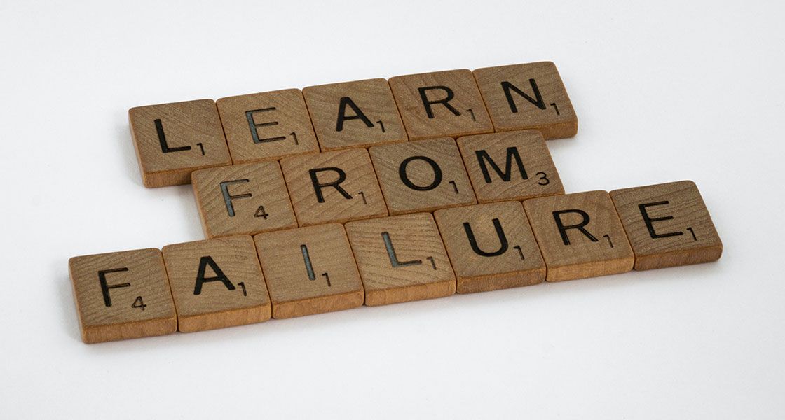 Wooden squares with letters on them that say "Learn From Failures"
